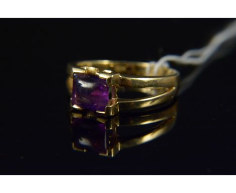 An 18ct yellow gold amethyst single stone ring, the square cabochon amethyst in four claw setting with split shoulders, size 