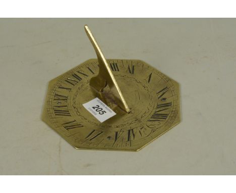 A brass sundial of octagonal form with engraved decoration and bearing date of 1760, 15cm wide