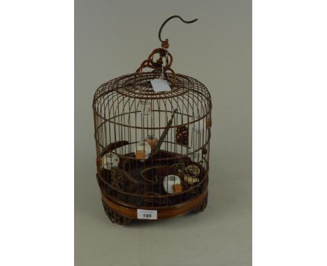 A modern Chinese ornamental bird cage of wire and carved wood construction and fitted with seven various ceramic feeders toge