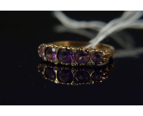 An unmarked amethyst and diamond set ring, the five oval amethysts interspaced with small diamonds in scrollwork setting, siz