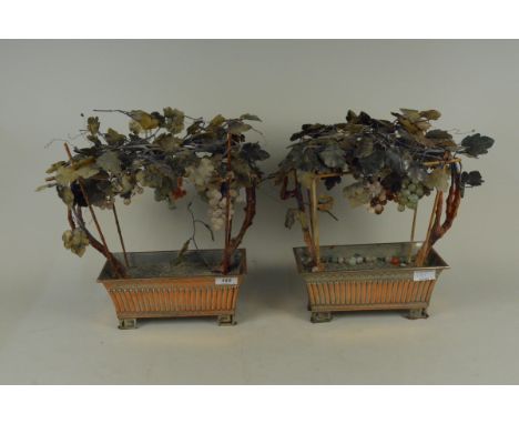 A pair of 20th Century Chinese hardstone table ornaments, each modelled in the form of fruiting grapevines in copper trough b