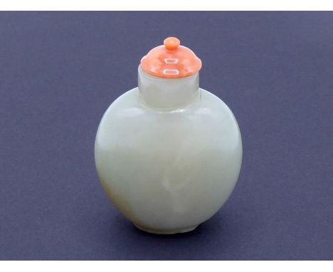 A Chinese carved pale celedon jade snuff bottle, of ovoid form on circular footed rim with plain carving on the body, coral c