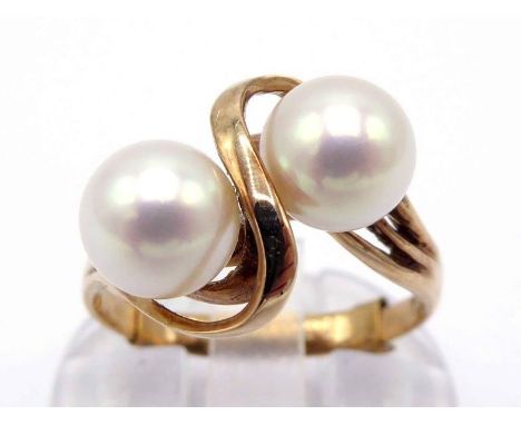 A cultured pearl ring, the two white pearls 6.7mm, in a cross over setting, the mount stamped '14k', finger size L, 3gms COND