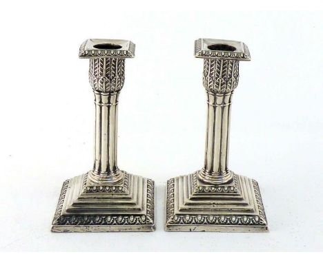 A pair of late Victorian silver dwarf candlesticks by William Hutton & Sons Ltd., London, 1895, with cluster columns and acan