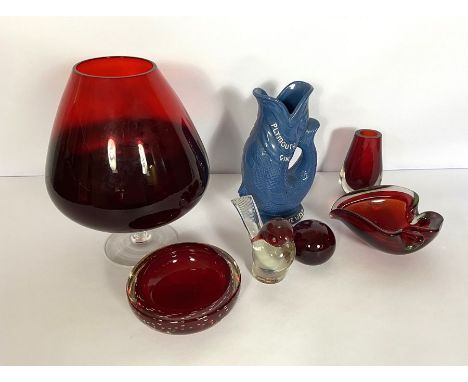 A group of ruby glassware, including a large 'goblet' vase and two ash trays; also a Plymouth Gin fish jug (7)