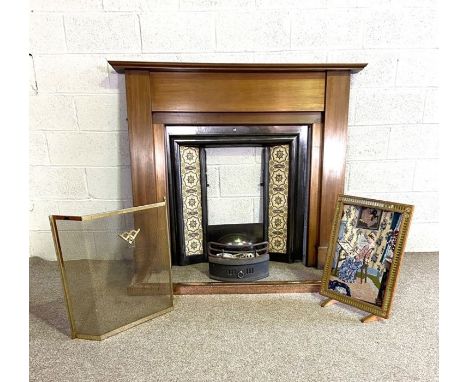 A late Victorian chimneypiece, including a mantel, cast iron centre and grate, set with later decorative tiles, also a fire c