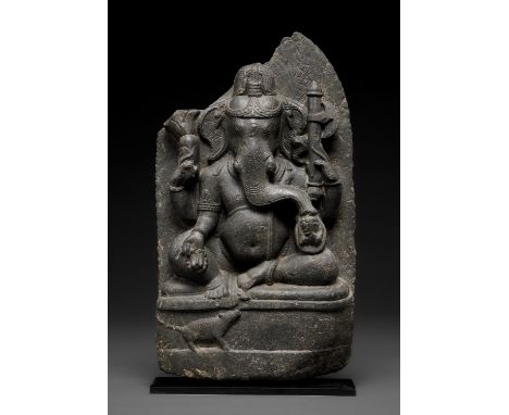 A BLACK STONE STELE OF GANESHA, PALA PERIODNortheastern India, circa 10th century. Seated in lalitasana, holding a mala, radi
