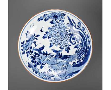 A LARGE BLUE AND WHITE 'PHOENIX AND PEONY' DISH, YU TANG (JADE HALL) MARK, TRANSITIONALChina, c. 1650-1660. The deep rounded 