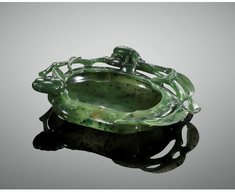 A SPINACH-GREEN JADE 'BEETLE AND LOTUS' WASHER, QING DYNASTYChina, 18th – 19th century. Finely worked as a lotus leaf with in