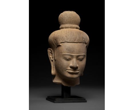 A LARGE SANDSTONE HEAD OF A MALE DEITY, BAPHUON STYLE, ANGKOR PERIODKhmer Empire, 11th century. Well carved with almond-shape