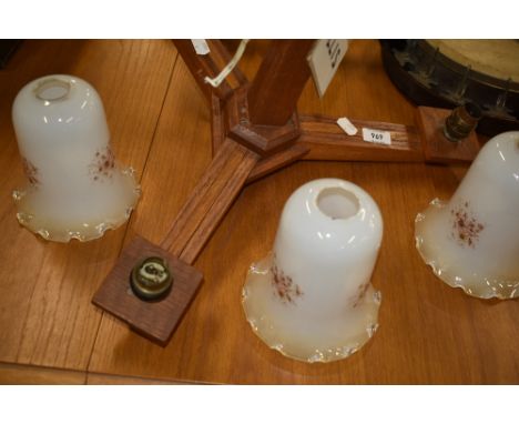 A vintage oak ceiling light fitting, three branch with opaque shades
