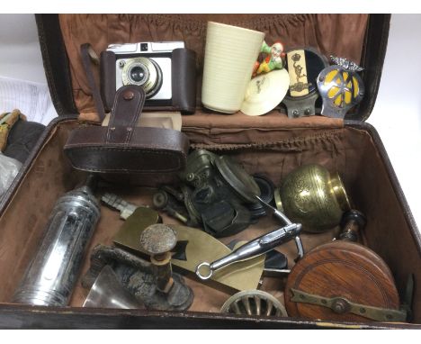 A suitcase of oddments comprising a fine quality wood plane, Clarice Cliff chocolate cup, fishing reel and other items. Shipp