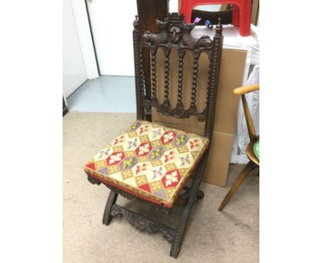 An elaborately carved chair with tapestry seat. Shipping category D.