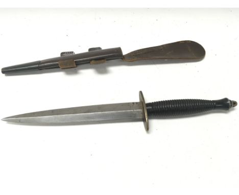 A Fairbairn Sykes fighting knife with leather scabbard. Postage D