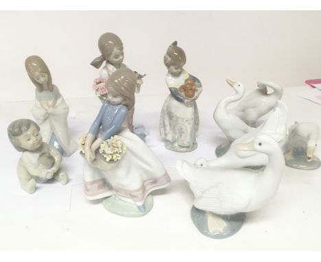 A collection of Lladro and Nao porcelain figures geese and children figures some minor damage to petals of flower heads.