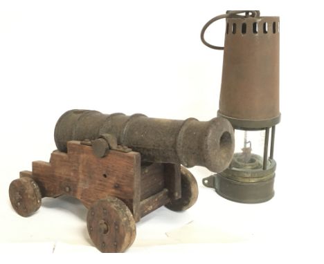 A small Cast iron cannon on a pine stand and a Richard Johnson miners lamp. This lot cannot be posted.