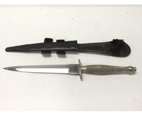 A Fairbairn Sykes fighting knife with leather scabbard. Postage D