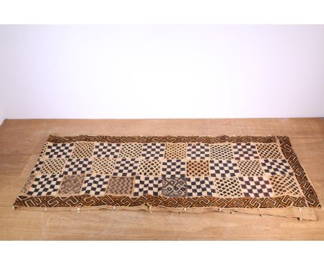 DRC, Kuba, two long raffia dance skirts. Patch work, geometrical design. One with cowrie shells at the borders. Damaged. [2] 