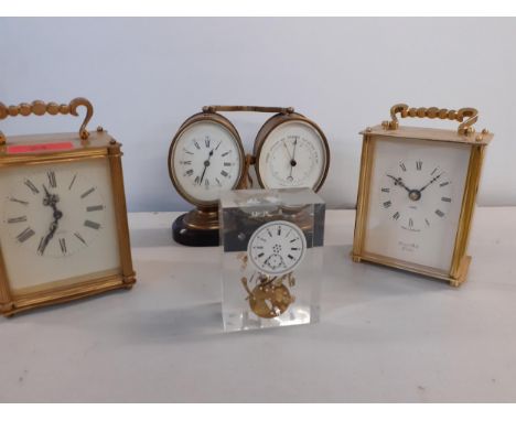 An early 20th century desk duo of barometer and clock on a mount together with two brass carriage clocks and a paperweight wi