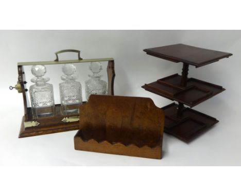 A three bottle glass decanter Tantalus in oak case, a small pipe rack and stand