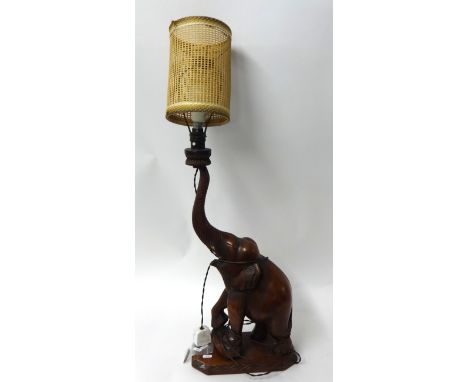 An Indian carved hardwood table lamp in the form of an elephant, (wood 56cm high)