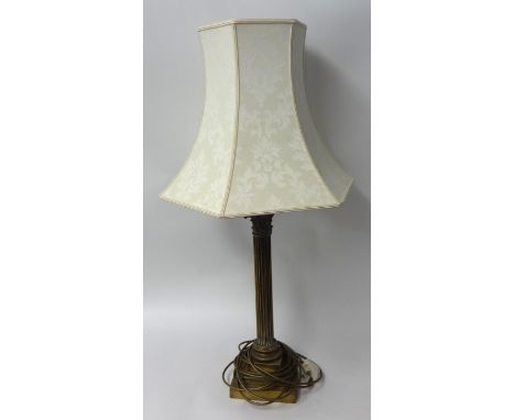 A tall brass table lamp with Corinthian column base