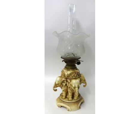 A porcelain table lamp modelled as three elephants with etched glass shade, possibly Royal Dux, 42cm high