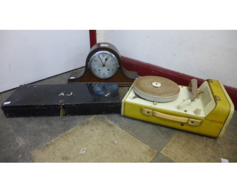 An H.M.V. table top gramophone, a portable record player, an oak mantel clock and a tin 