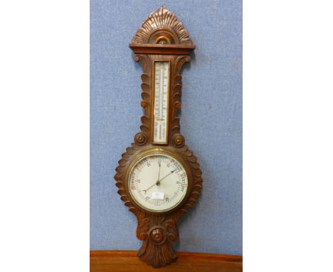 An Edward VII carved oak aneroid barometer 