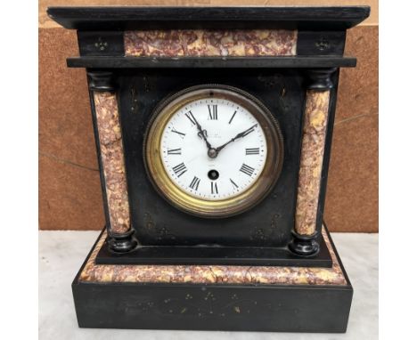 A black slate mantle clock, of architectural form with an enamel dial and Roman numerals 