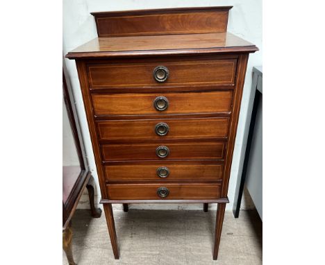 An Edwardian inlaid mahogany music cabinet with a raised back and six drawers with drop fronts on square tapering legs, 55cm 