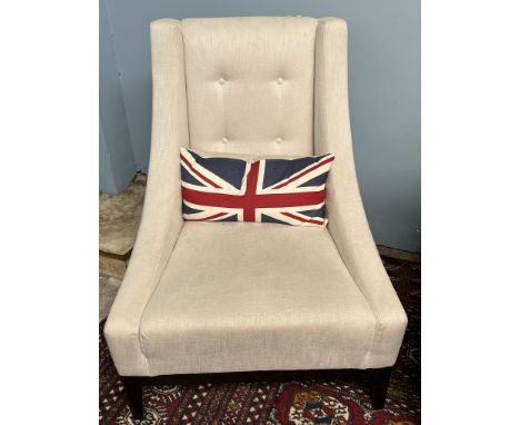 A pair of modern upholstered arm chairs in cream with button back upholstery on square tapering legs