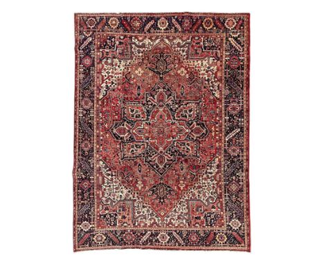 Persian Heriz crimson ground carpet, large central medallion comprising projecting palmettes with surrounding stylised plant 