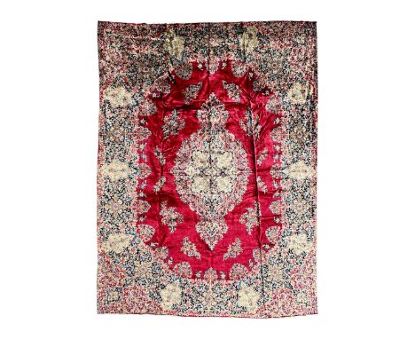 Persian Kirman carpet, the bold ruby field hosting a multi-lobed central medallion, embellished with scrolling vines and flor