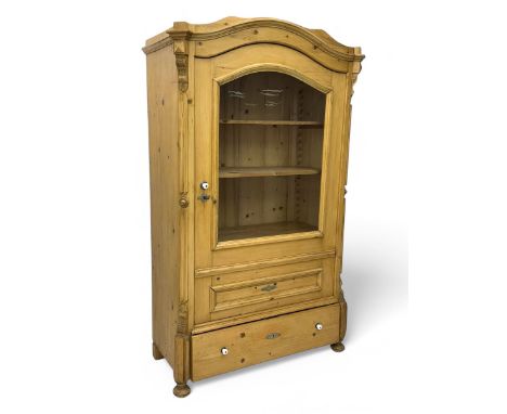 Late 19th century Continental pine vitrine, shaped and moulded arched cornice over a single glazed door enclosing adjustable 