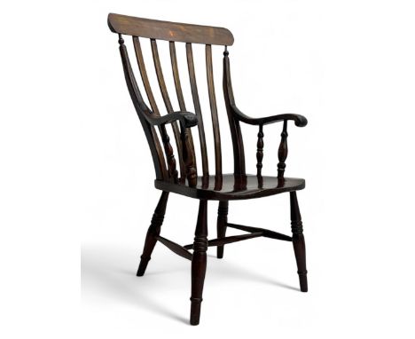 Early 20th century ash and elm farmhouse armchair, with curved top rail above seven stick spindles and shaped arms on ring tu