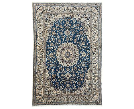 Persian Kashan blue ground rug, central floral rosette medallion within a field of swirling branches and palmettes, the borde