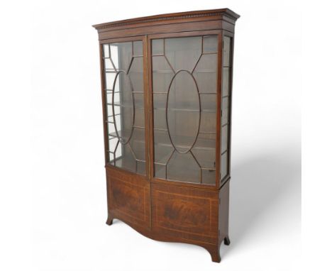 Edwardian mahogany and satinwood bow-fronted display cabinet, moulded dentil cornice over two astragal glazed doors, fitted w