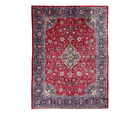 Kashan crimson ground carpet, overall floral design, the central medallion surrounded by trailing leafy branches and palmette
