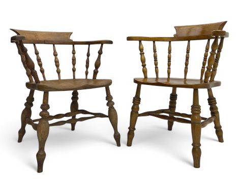 Late 19th century elm smoker’s bow armchair, curved top rails over turned spindle backs, shaped seats, raised on turned legs 