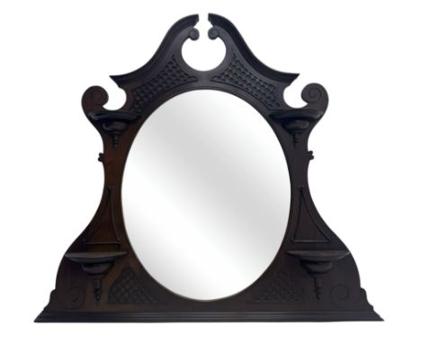 Early 20th century mahogany overmantel mirror, shaped broken pediment crest with open lattice panels, oval mirror plate flank