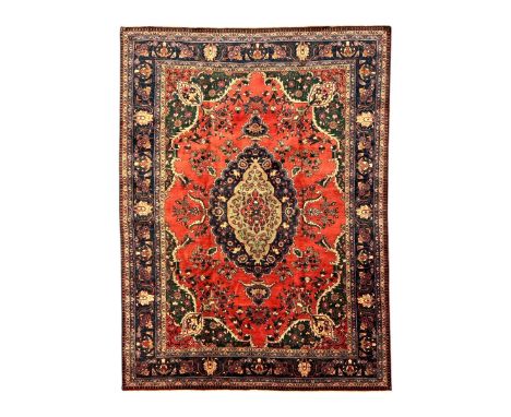 North East Persian Meshed crimson ground carpet, central indigo and green medallion with floral decoration, busy field with t