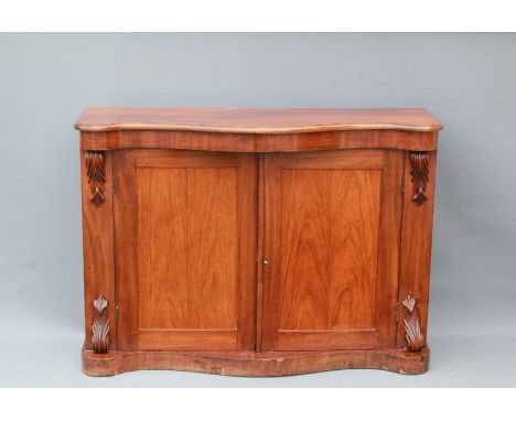 A Victorian Rosewood Chiffonier. The shaped front over double doors opening to one shelf within, carvings to side columns, ap