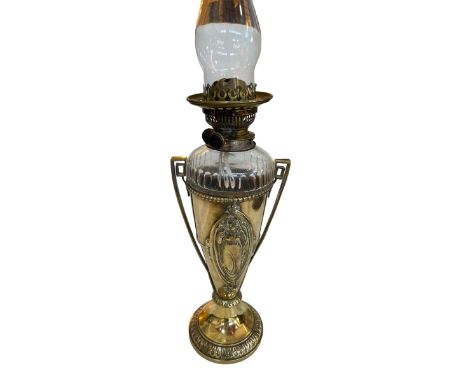 Ornate brass urn style oil lamp with clear glass reservoir.