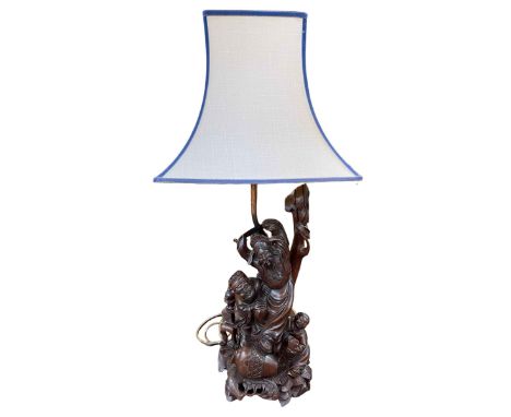 Ornate carved root wood table lamp depicting Oriental men, with shade, 82cm.