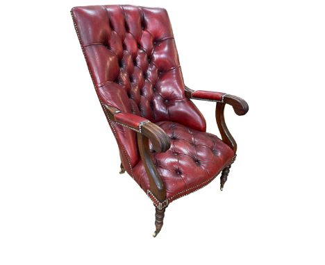 Red leather button back library chair on turned legs.