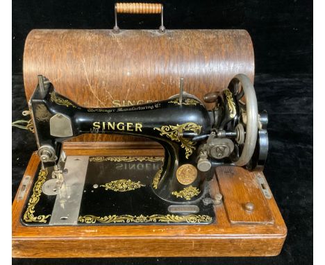 A Singer manual sewing machine and accessories, wooden carry case 