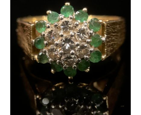 An 18ct gold emerald and diamond cluster ring, size T, textured bark shank, London 1976, 8g 