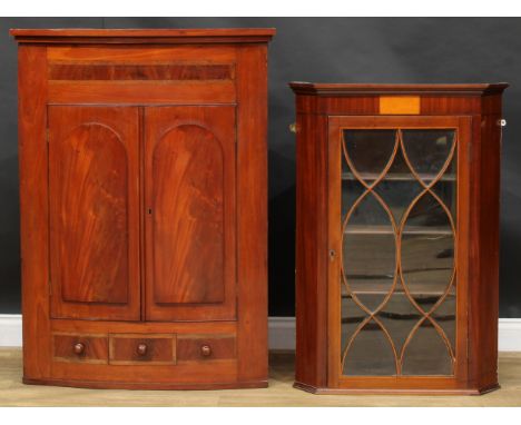 A Victorian mahogany bow front corner cabinet, stepped cornice above a pair of doors enclosing two shelves, above a small spi