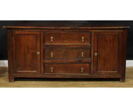 An oak low dresser, rectangular top above three drawers flanked by panel doors, each enclosing a shelf, 85.5cm high, 186cm wi